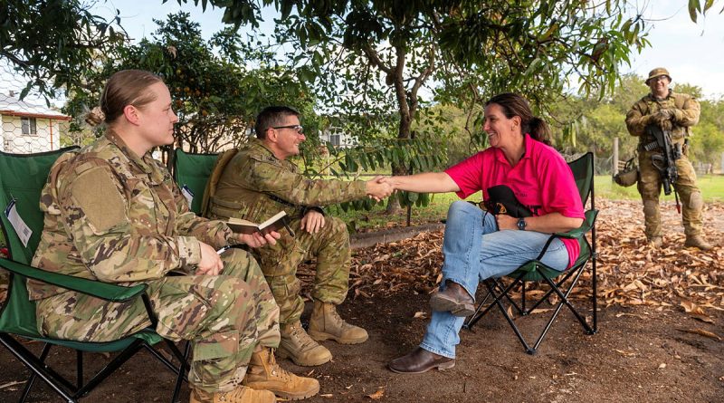 United States Army Public Affairs Staff Sergeant Brittney Adams and Warrant Officer Class 2 Shane Harris speak with a civilian role player while Private James Hoffman stands nearby in Ingham, Queensland as part of Exercise Talisman Sabre 2023. Story by Major Jesse Robilliard. Photo by Corporal Michael Currie.