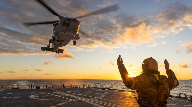 Leading Seaman Thomas Baskerville marshals a Japan Maritime Self-Defense Force SH-60K Super Auk, from JS Shiranui, to land on HMAS Brisbane during Exercise Malabar. Story by Lieutenant Marcus Middleton. Photos by Leading Seaman Matthew Lyall.