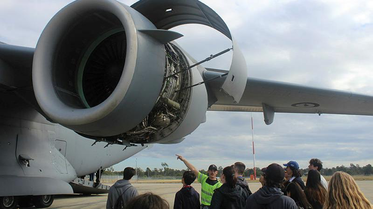 Leading Aircraftman Seth Bamblett, from 36 Squadron, explains the mechanical components of a C-17A Globemaster engine to AYAF students.