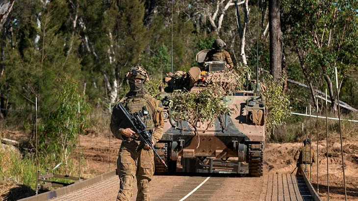 An Australian sapper from 2nd Combat Engineer Regiment guides an M113 armoured personnel carrier over the new dry support bridge during Exercise Talisman Sabre 2023. Story by Major Roger Brennan. Photos by Corporal Nicole Dorrett.