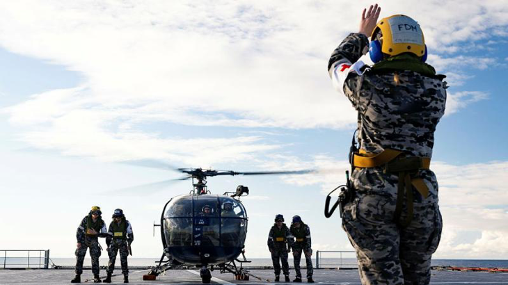 Leading Seaman Kendall Warner marshals an Indian Navy Chetak helicopter on board HMAS Choules during Exercise Malabar 2023, NSW. Story by Sub-Lieutenant Tahlia Merigan. Photo by Leading Seaman David Cox.