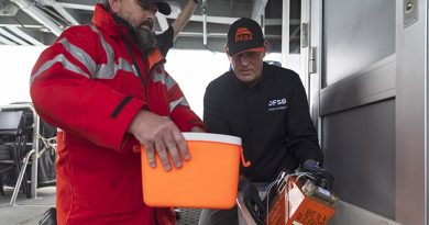 Defence Flight Safety Bureau safety investigator flight data recovery specialist Justin Galbraith (right) and an Australian Transport Safety Bureau investigator prepare the recovered MRH-90 Taipan voice and flight data recorder for transport at Whitsunday Islands (7 August 2023). Photo by Corporal Lisa Sherman.