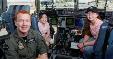 Squadron Leader Chris Moore (left) from 36 Squadron, with patients Jamie (center) and Sophia from the Queensland Children's Hospital, on the flight deck of a C-17A Globemaster III at RAAF Base Amberley. Story by Squadron Leader Tina Turner. Photo by Sergeant Peter Borys.