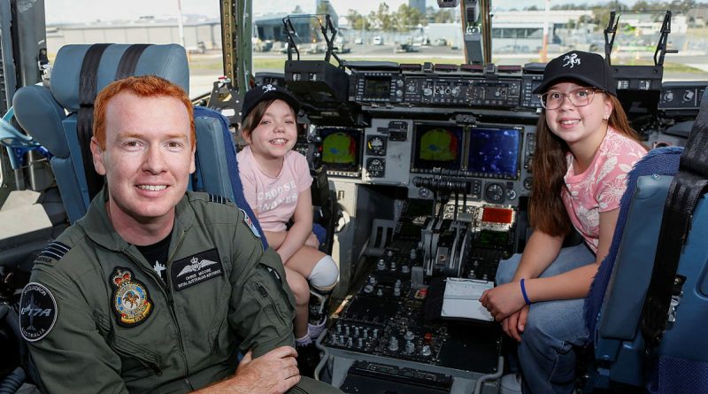 Squadron Leader Chris Moore (left) from 36 Squadron, with patients Jamie (center) and Sophia from the Queensland Children's Hospital, on the flight deck of a C-17A Globemaster III at RAAF Base Amberley. Story by Squadron Leader Tina Turner. Photo by Sergeant Peter Borys.