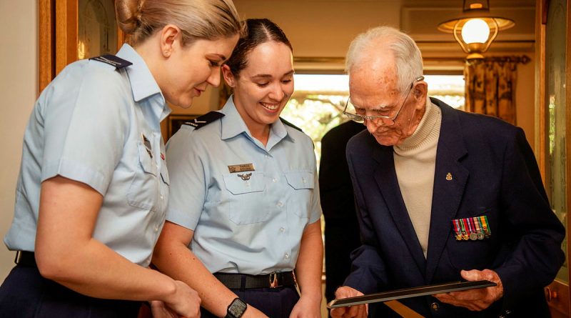 Leading Aircraftwomen Erica Moy and Tahlia Kitchin, from 83 Squadron, and Lyall Ellers reflect on his Air Force service during his 100th birthday celebrations held at his home in Seacliff, Adelaide, SA. Photos by Sergeant Nicci Freeman.