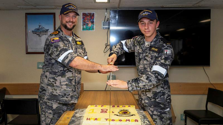 Commanding Officer HMAS Toowoomba Commander Darin MacDonald, left, and youngest crewmember, Seaman Jack Lefevre, cut Toowoomba’s 18th birthday cake during a regional presence deployment. Story by Story by Lieutenant Commander Andrew Herring. Photo by Leading Seaman Ernesto Sanchez.
