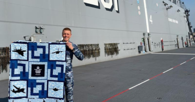 Flight Lieutenant Kristian Henderson proudly displays his Aussie Hero Quilt, received while deployed with HMAS Adelaide on Operation Tonga Assist 22. Story by Squadron Leader Jessica Aldred.
