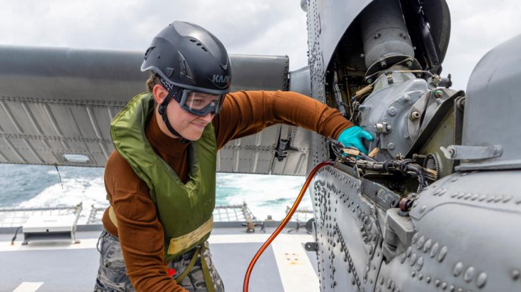Navy aviation technician Able Seaman Casey Anderson, of HMAS Toowoomba, takes oil samples from the embarked MH-60R helicopter Valkyrie during a regional presence deployment. Story and photo by Leading Seaman Ernesto Sanchez.
