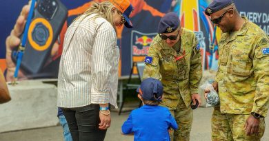 Australian Army soldiers Lance Corporal Ashleigh Jackson, centre, and Private Lib Savrimuthu, right, interact with a family at the MotoGP 2023, Phillip Island. Story by Captain Kristen Cleland and Captain Andrew Lee. Photos by Captain Andrew Lee.