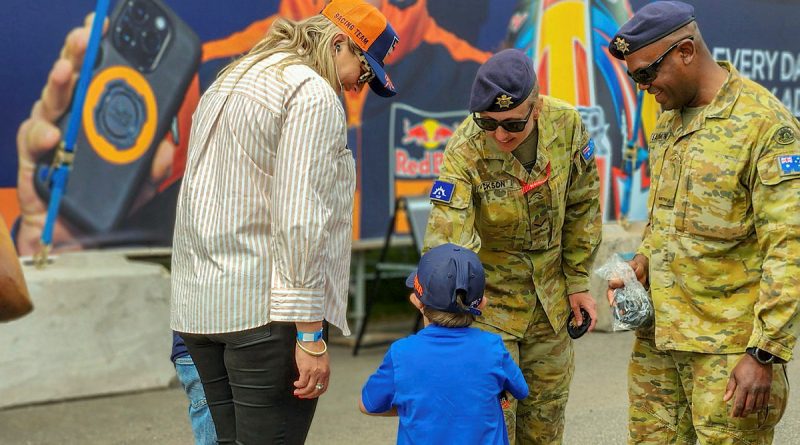 Australian Army soldiers Lance Corporal Ashleigh Jackson, centre, and Private Lib Savrimuthu, right, interact with a family at the MotoGP 2023, Phillip Island. Story by Captain Kristen Cleland and Captain Andrew Lee. Photos by Captain Andrew Lee.
