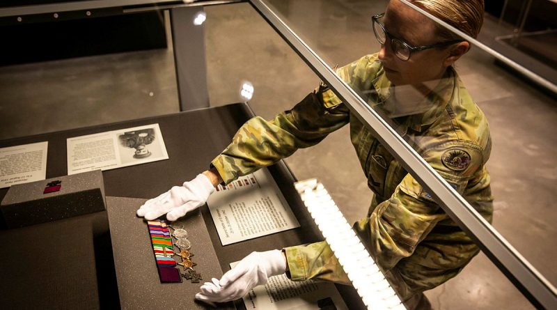 Corporal Stacey Kitcher from Army History Unit places a Victoria Cross and medal set into the display case at the Australian Army Infantry Museum, Singleton. Story and photos by Corporal Melina Young.