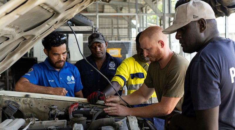 Australian soldier Craftsman Bradley Scheef and members of the Royal Solomon Islands Police Force (RSIPF) maintain a police vehicle in preparation for the Pacific Games. Story by Major Roger Brennan. Photos by Leading Seaman Jarrod Mulvihill.