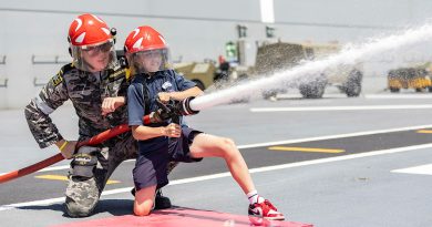 A HMAS Adelaide sailor helps a student from Navy Life Experience with fire hose operations during the inaugural Navy Life Expo in Sydney. Story by Lieutenant Jonathan Wills. Photos by Able Seaman Lucinda Allanson.