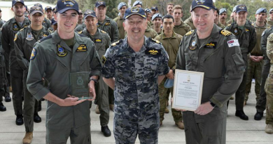 Commander Fleet Aviation Arm Commodore David Frost presents the 2022 McNichol Trophy to then Seaman Joshua Williams (left) and Commanding Officer 723 Squadron Commander Samuel Dale during a gathering at 723 Squadron, HMAS Albatross. Story by Sam Carter. Photo by Petty Officer Peter Thompson.