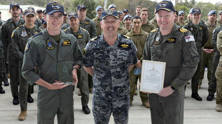 Commander Fleet Aviation Arm Commodore David Frost presents the 2022 McNichol Trophy to then Seaman Joshua Williams (left) and Commanding Officer 723 Squadron Commander Samuel Dale during a gathering at 723 Squadron, HMAS Albatross. Story by Sam Carter. Photo by Petty Officer Peter Thompson.