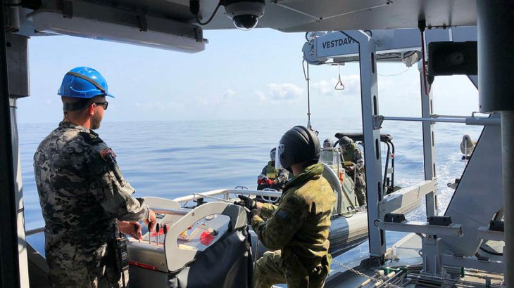 ADV Cape Capricorn's seaboat is recovered with the help of Private Crosher under the guidance of the davit operator, Leading Seaman Matthew Anderson, during a sea-experience day.