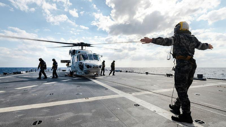 Leading Seaman Ruben Villis marshals personnel from JS Sazanami’s embarked Super Auk helicopter as it prepares to take-off from HMAS Brisbane during a cross-deck in the Philippine Sea as part of Exercise Nichi Gou Trident. Story by Lieutenant Max Logan. Photo by Leading Seaman Daniel Goodman.