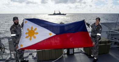 HMAS Toowoomba sailors Petty Officer Peter Sutton, left, and Able Seaman Finn Jackson display the national flag of the Philippines during the inaugural maritime cooperative activity during a regional presence deployment. Story by Lieutenant Commander Kieran Davis.