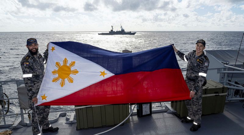 HMAS Toowoomba sailors Petty Officer Peter Sutton, left, and Able Seaman Finn Jackson display the national flag of the Philippines during the inaugural maritime cooperative activity during a regional presence deployment. Story by Lieutenant Commander Kieran Davis.