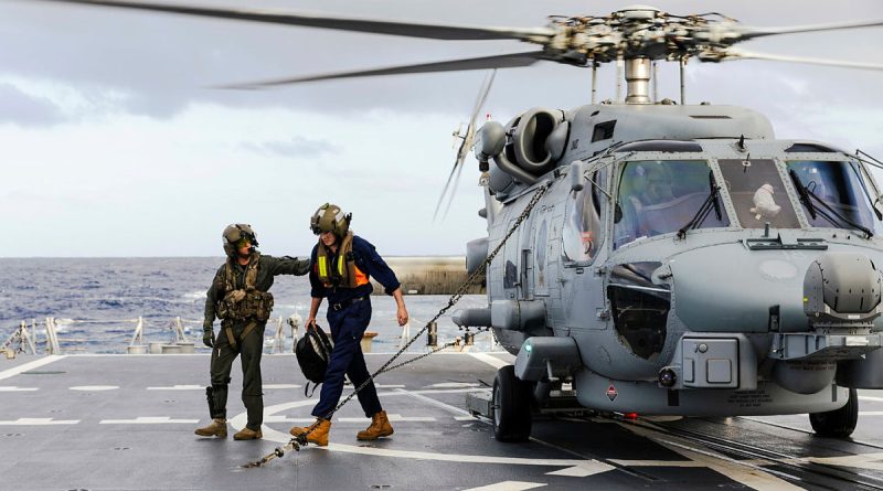 Leading Seaman Matthew Parry escorts Liam Glackin from HMAS Brisbane’s embarked MH-60R helicopter while conducting an evacuation from Willis Island off the coast of Queensland. Story by Lieutenant Commander Andrew Herring.