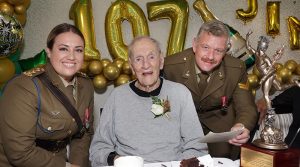 Captain Shani Edwards and Corporal Matthew Woods join birthday boy James Easton for chocolate cake.