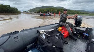 Royal Australian Navy personnel work with civilian emergency services to evacuate members of the public from Holloways Beach using a stretch of the Captain Cook Highway near the Barron River Bridge. Photographer unknown.