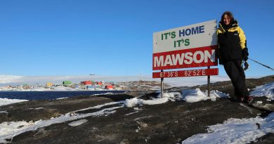Squadron Leader Catherine Humphries with the "It's Home It's Mawson" sign at the research station. Story by Corporal Veronica O’Hara.