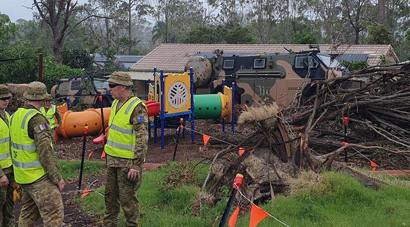Aussie soldiers plan their cleanup work at the Oxenford State School where large trees fell during Christmas-holiday storms and needed to be removed. Photo by Sergeant Hatcher.