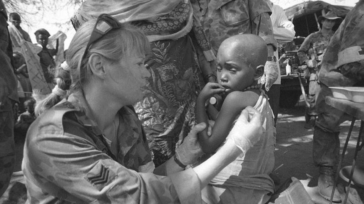 Australian Army Medic, then Sergeant Joanne Cook, examines a little girl with malaria in February 1993. Story by Corporal Luke Bellman. Photo by Corporal Gary Ramage.