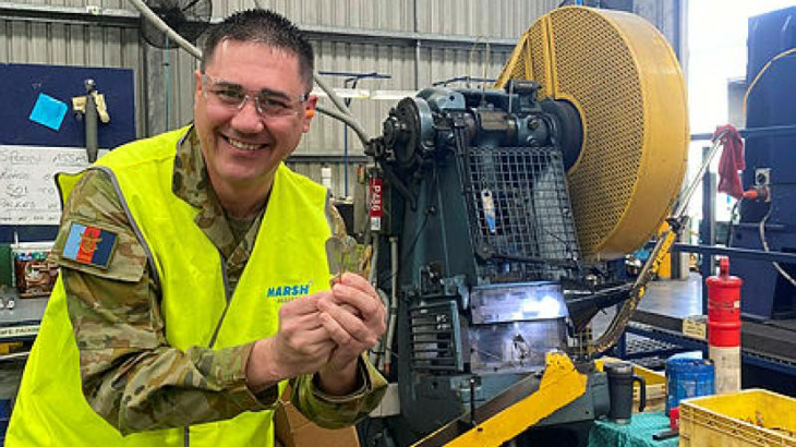 Captain Andre Borg with a new field ration eating device (FRED) at the manufacturing workshop in Queensland. Story by Corporal Michael Rogers.