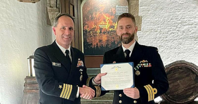 Rear Admiral Lincoln Reifsteck, US Navy, presents Commander Daniel McCall, Royal Australian Navy, with a citation that accompanies the US Navy and Marine Corps Commendation Medal.