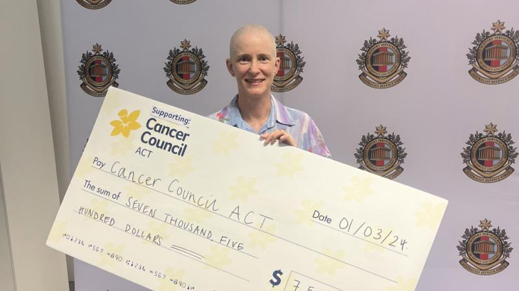 Narelle Powers after having her head shaved at Reserve and Cadet Support Headquarters, holding a cheque for $7500. Photo by Emily Egan.