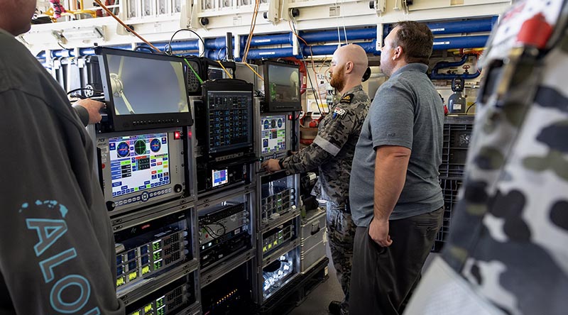 US Missile Defence Agency member Steven Foster shows Royal Australian Navy Petty Officer Thomas Dann how to control detection equipment in the Hanger of HMAS Stuart during a missile-detection test off Hawaii. Photo by Leading Seaman Rikki-Lea Phillips.
