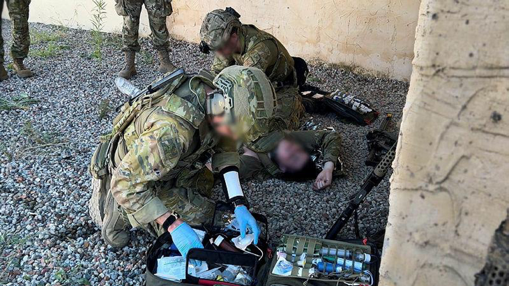 Special operations first-aid course participants assess a casualty role-player and prepare for field medical care under the supervision of Australian and American directing staff. (Images have been digitally altered for security purposes.). Story by Major N.