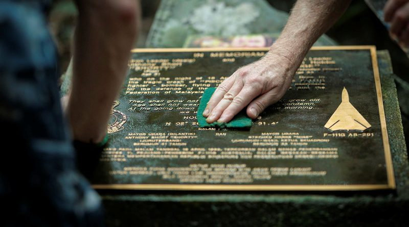 Royal Australian Air Force Wing Commander David Riddel and Mark Johnson clean the memorial plaque at the crash site of F-111G A8-291, in Pulau Aur, Malaysia. Story. y Flight Lieutenant Rob Hodgson. Photos by Leading Aircraftman Kurt Lewis.