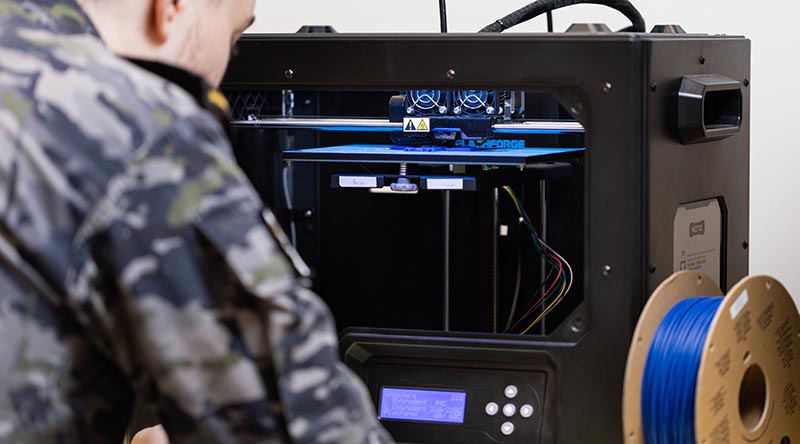Royal Australian Navy sailor Able Seaman Dillan Ackerman oversees 3D printed engineering parts at Fleet Support Unit – South East, Sydney. Photo by Leading Seaman Jarrod Mulvihill.