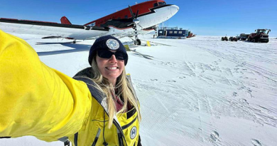 Lieutenant Holly Boubouras in front of a Basler aircraft at Casey Skiway before a flight to Bunger Hills, Antarctica.