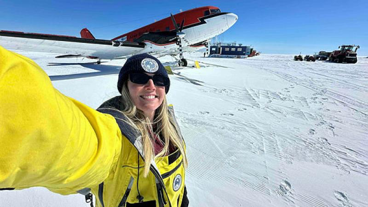 Lieutenant Holly Boubouras in front of a Basler aircraft at Casey Skiway before a flight to Bunger Hills, Antarctica.