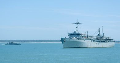 Royal Australian Navy Armidale-class patrol boat HMAS Bathurst sails past USS Emory S. Land as the United States Navy ship prepares to come alongside Kuru Wharf at HMAS Coonawarra, Darwin, NT, during her visit of Australia. Photo by Petty Officer Leo Baumgartner.