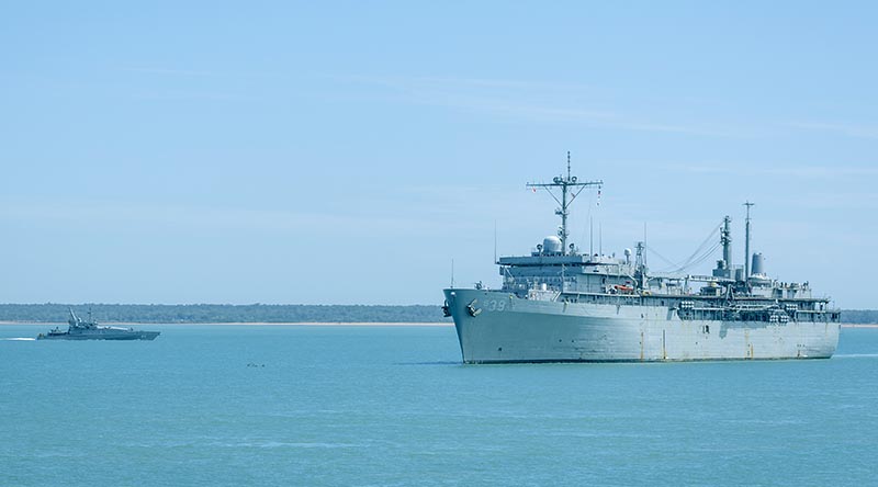 Royal Australian Navy Armidale-class patrol boat HMAS Bathurst sails past USS Emory S. Land as the United States Navy ship prepares to come alongside Kuru Wharf at HMAS Coonawarra, Darwin, NT, during her visit of Australia. Photo by Petty Officer Leo Baumgartner.