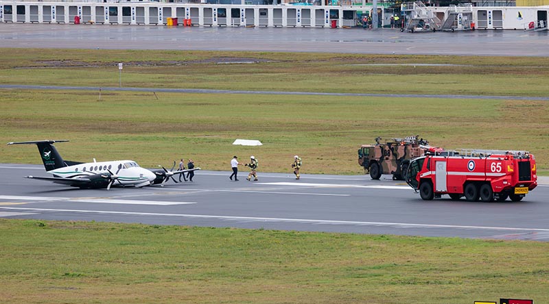 Royal Australian Air Force aviators from No. 26 Squadron provide assistance to occupants disembarking Beechcraft B200 Super King Air VH-XDV after an emergency wheels-up landing at Newcastle Airport, NSW. Photo by Leading Aircraftman Kurt Lewis.