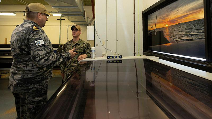Petty Officer Darren Trewern speaks with a member of USS Emory S. Land during a tour of Fleet Support Unit – North during a port visit to Darwin. Story by Lieutenant Commander Rebecca Williamson. Photo by Petty Officer Leo Baumgartner.