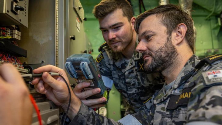 Electronics technicians Able Seaman William Clayton, left, and Leading Seaman Matthew Jarman inspect a component in a radar room following a damage control scenario aboard HMAS Adelaide. Story and photo by Corporal Jacob Joseph.