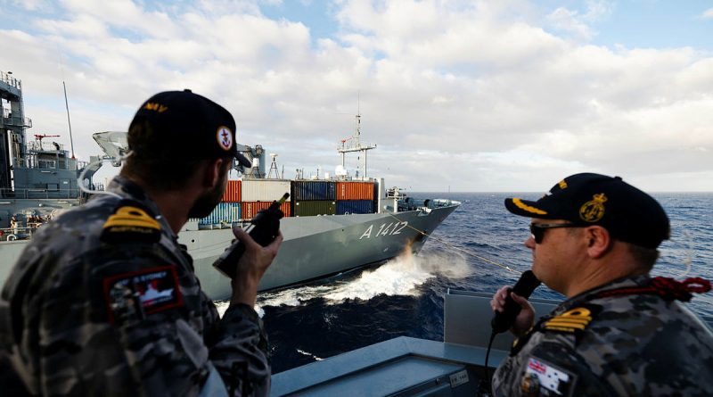 Lieutenant Nicholas Dale, left, and Commanding Officer HMAS Sydney Commander Billy Maddison steer the ship during a replenishment at sea with German Navy Ship Frankfurt Am Main during Exercise Rim of the Pacific 2024. Story by Lieutenant Tahlia Merigan. Photos bu Leading Seaman Daniel Goodman.