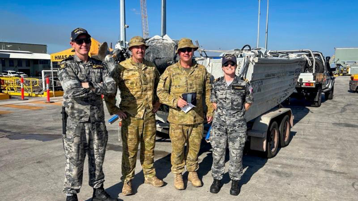 Navy sailors from HMAS Perth, Chief Petty Officer Glen Nipperess, left, and Lieutenant Commander Gemma Casserly, return a recovered craft to its owner, Army soldier Warrant Officer Class Two Carl Stanley, centre right, at HMAS Coonawarra. Story and photo by Corporal Michael Rogers.
