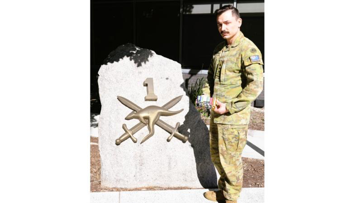 Army Captain Blake Parbery holds his grandfather Gordon Wells' service medals, outside Headquarters 1st (Australian) Division, Gallipoli Barracks, Enoggera, Queensland. Story and photo by Captain Peter Nugent.