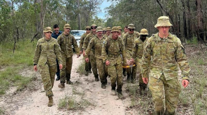 ADF Members and Queensland Ambulance Service personnel stretcher a man, who had been missing, through bushland to emergency service vehicles. Story by Lieutenant Commander Nic Hawkins. Photo from Queensland Police Service.