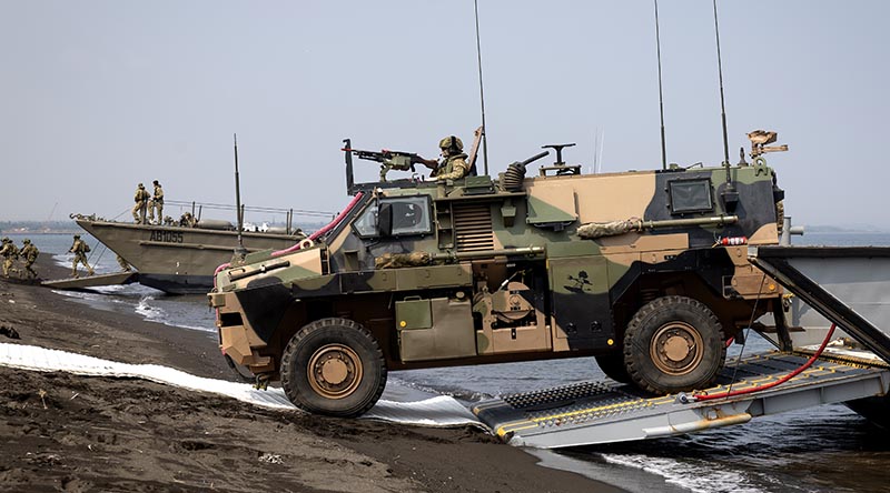 An Australian Army Bushmaster protected mobility vehicle disembarks from a landing craft during Exercise Keris Woomera at Banongan Beach, Indonesia. Photo by Leading Seaman Rikki-Lea Phillips.