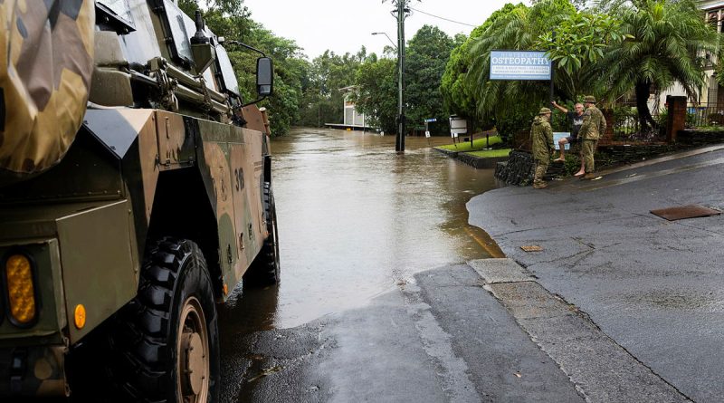 Sergeant Paul Dennis, left, and Lieutenant Jack Macklan talk to Lismore resident Chris McNamara near the flooded Wilsons River during a joint patrol to monitor floodwaters as part of Operation Topical Cyclone Alfred Assist. Story by Lieutenant Emily Tinker. Photos: byWarrant Officer Class 2 Raymond Vance.