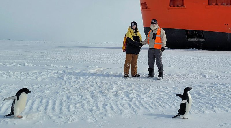Squadron Leader Anthony Rengel receives handover from the 77th ANARE medical practitioner Dr Peter Rizzo near the RSV Nuyina and local Adelie penguins.
